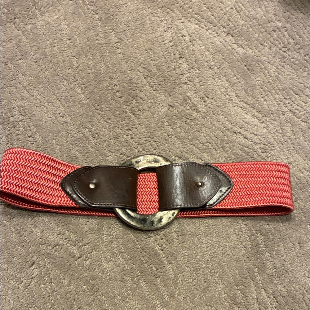 Stretchy rose colored belt with leather and large pounded silver toned circle